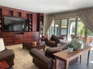 巴莉斯的住宿－Riverfront Golf Estate House，客厅配有皮革家具和平面电视