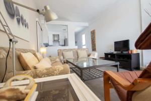 ein Wohnzimmer mit einem Sofa und einem Tisch in der Unterkunft Apartamento cerca del mar in Poris de Abona