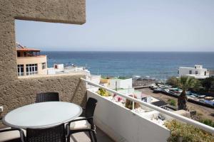 balcón con mesa y vistas al océano en Apartamento cerca del mar en Poris de Abona