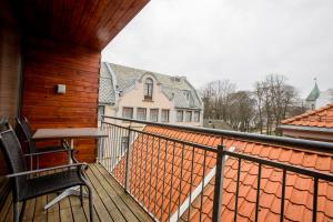una casa con balcón con mesa y sillas en Klostergaarden leilighetshotell, en Stavanger