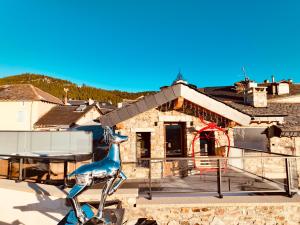 a house with a blue chair on a balcony at Le Refuge Cal Chalon , chalet de luxe au cœur du village in Les Angles