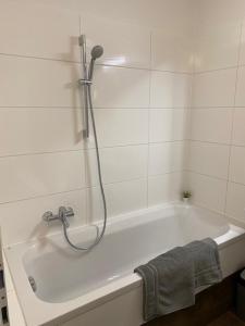 a bathroom with a bath tub with a shower at Paky Appartements 00316 in Bruck an der Leitha