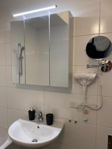 ein Bad mit einem Waschbecken und einem Spiegel in der Unterkunft Paky Appartements 00316 in Bruck an der Leitha