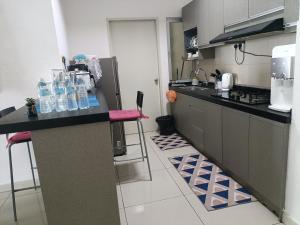 a kitchen with a counter with bottles of water on it at Cikta Homestay at Southville City Savanna Suite in Kampong Tangkas