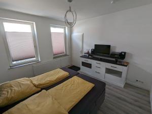 1 dormitorio con 1 cama y TV. en Gemütliche 2-Zi-Whg, Strandnähe, kostenloser Parkplatz, Schlüsselbox, 24/7 Selfcheckin en Flensburg