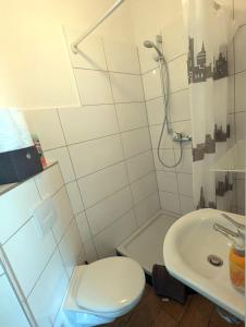 La salle de bains blanche est pourvue de toilettes et d'un lavabo. dans l'établissement Gemütliche 2-Zi-Whg, Strandnähe, kostenloser Parkplatz, Schlüsselbox, 24/7 Selfcheckin, à Flensbourg