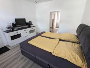 a bedroom with a bed with a tv on it at Gemütliche 2-Zi-Whg, Strandnähe, kostenloser Parkplatz, Schlüsselbox, 24/7 Selfcheckin in Flensburg