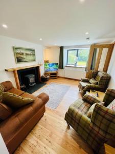 a living room with two couches and a fireplace at Barty’s Bothy in Contin