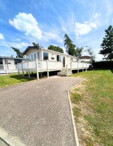 a mobile home with a porch and a driveway at Haven Holiday Home at Kent Coast Allhallows in Rochester