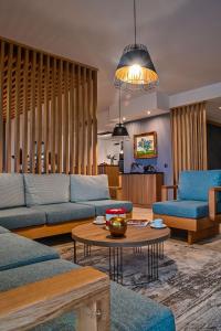 a living room with blue couches and a table at BlackSeaRama Golf & Villas in Balchik