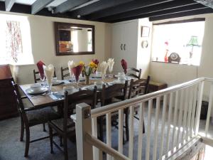 a dining room with a table with chairs and a tableablish at The Cottage on the Green in Winkleigh