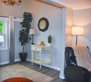 a bedroom with a table and a clock on the wall at 2 bedroom with queen sofa sleeper in Nashua