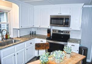 een keuken met witte kasten en een fornuis met oven bij 2 bedroom with queen sofa sleeper in Nashua