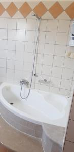 a white bath tub with a shower in a bathroom at sunset house in Vitalades +11 photos