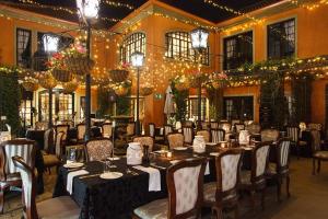 uma sala de jantar com mesas, cadeiras e luzes em Ivory Manor Boutique Hotel em Pretoria
