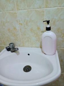 a soap dispenser sitting on top of a white sink at Mkombodzi Global Homes in Mtwapa