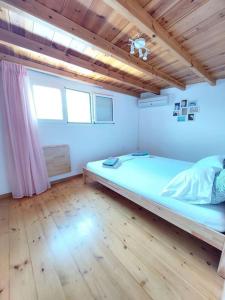 a bedroom with a large bed and a wooden floor at Katerina's traditional house in lefkes village in Lefkes