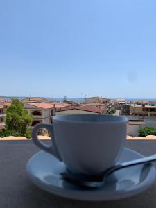 uma chávena de café sentada num pires com uma colher em LE CASTELLA BEACH S.F.2 em Le Castella