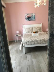 a bedroom with a white bed and a pink wall at Flor&Fidalgo Guest House in Sintra