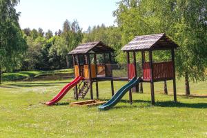 un parque infantil con 2 toboganes y un cenador en Lejasbisenieki en Turaida