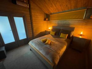 a bedroom with a bed with two yellow pillows at Daisy Cabin in Kincardine OʼNeil