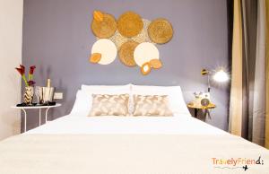 Spacious & Central Apartament في سانتياغو دي كومبوستيلا: غرفة نوم مع سرير أبيض مع قبعات على الحائط