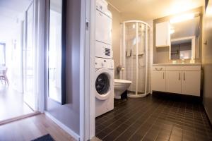 La salle de bains est pourvue d'un lave-linge et d'un sèche-linge. dans l'établissement Klostergaarden leilighetshotell, à Stavanger