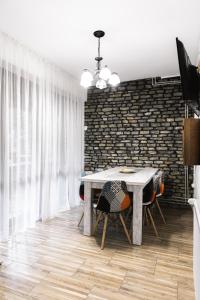 a dining room with a table and chairs and a brick wall at Vilele Voineasa in Voineasa