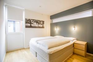 Un dormitorio con una gran cama blanca y una ventana en Klostergaarden leilighetshotell, en Stavanger