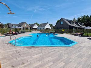 een groep mensen in een zwembad bij Chalet 572 op Recreatiepark De Wielen in Sint Maarten