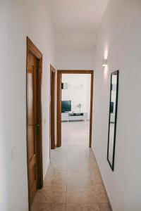 um corredor com duas portas e um espelho na parede em Casa a 3 minutos del Casco y con facil aparcamiento- El rincón de Carmela em Talavera de la Reina