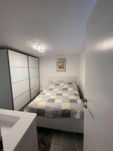 um pequeno quarto com uma cama e um lavatório em Komfortables residieren in stilvoller Wohnung em Böblingen