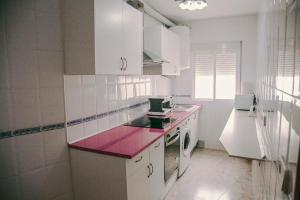 una cucina con armadi bianchi e ripiano rosa di Casa a 3 minutos del Casco y con facil aparcamiento- El rincón de Carmela a Talavera de la Reina Altre 29 foto