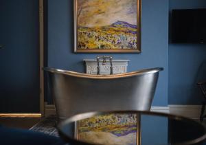 uma cadeira de prata num quarto com uma pintura em The Bear, Cowbridge em Cowbridge