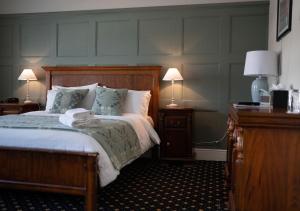 a bedroom with a bed with two lamps and two tables at The Bear, Cowbridge in Cowbridge