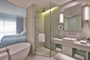 y baño con ducha de cristal, bañera y lavamanos. en The Westin City Centre Bahrain en Manama