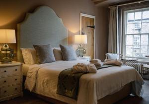 ein Schlafzimmer mit einem großen Bett, auf dem Handtücher liegen in der Unterkunft The Bear, Cowbridge in Cowbridge