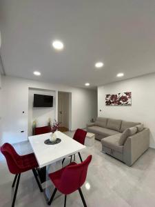 a living room with a couch and a table and red chairs at Apartments Luce - Dome in Split