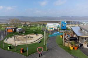 Haven Holiday Home at Kent Coast Allhallows في روتشستر: حديقة مع ملعب مع منطقة لعب