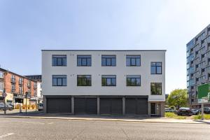 a white building with black windows on a street at Flatzy - 16 Guests 4 En-suite Central Apartment B in Liverpool