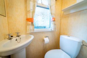 baño con aseo y lavabo y ventana en Camping KamA, en Mikołajki