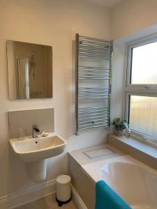 a bathroom with a sink and a tub and a mirror at Beautiful apartment in Harrogate, North Yorkshire in Harrogate