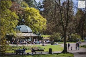 a group of people sitting on benches in a park at Beautiful apartment in Harrogate, North Yorkshire in Harrogate