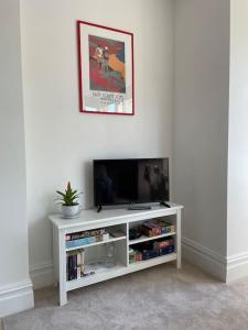 a white entertainment center with a flat screen tv at Beautiful apartment in Harrogate, North Yorkshire in Harrogate