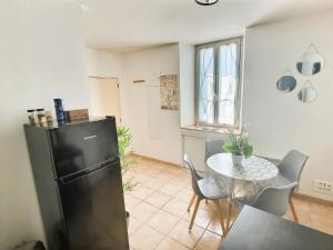 a kitchen and dining room with a table and a refrigerator at Le 3plex - Coeur de Vertou - Original in Vertou