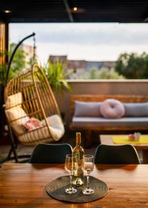 a table with two wine glasses and a chair at Just 4 You in Komiža
