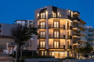 a tall apartment building with its lights on at Vespera City Hotel in Heraklio +25 photos