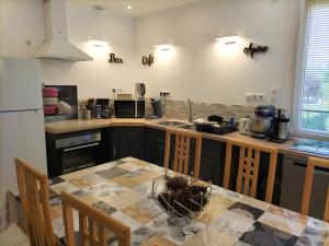 a kitchen with a table and a counter top at Gîte les Dames du Quint 3 étoiles in Baume-les-Dames +10 photos