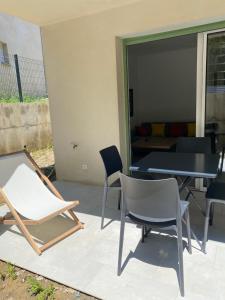 patio con sedie, tavolo e divano di Résidence Arborea C3 Corte a Corte