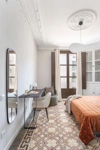 バルセロナにあるPremium 1 - 2 bedroom design apartments near Merce squareのベッドルーム(ベッド1台、デスク、鏡付)